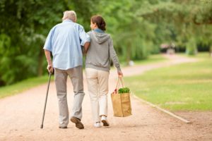 Older man walking with young woman who is carrying a shopping bag