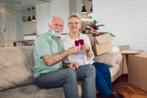 Older couple enjoying a glass of wine on the sofa